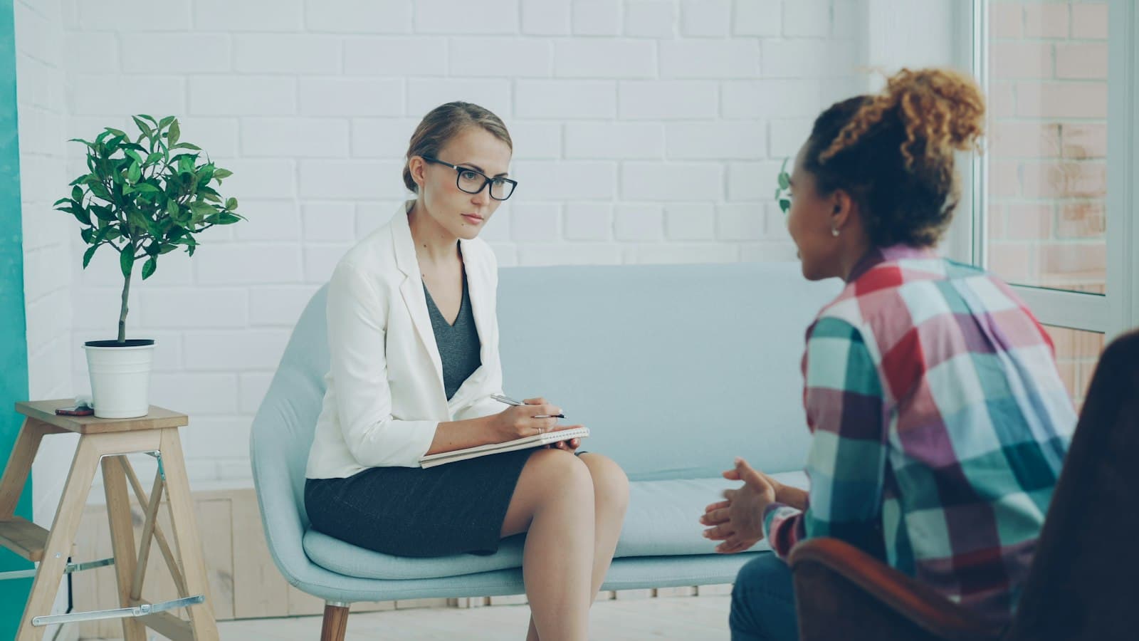 A therapist taking notes while listening to a client
